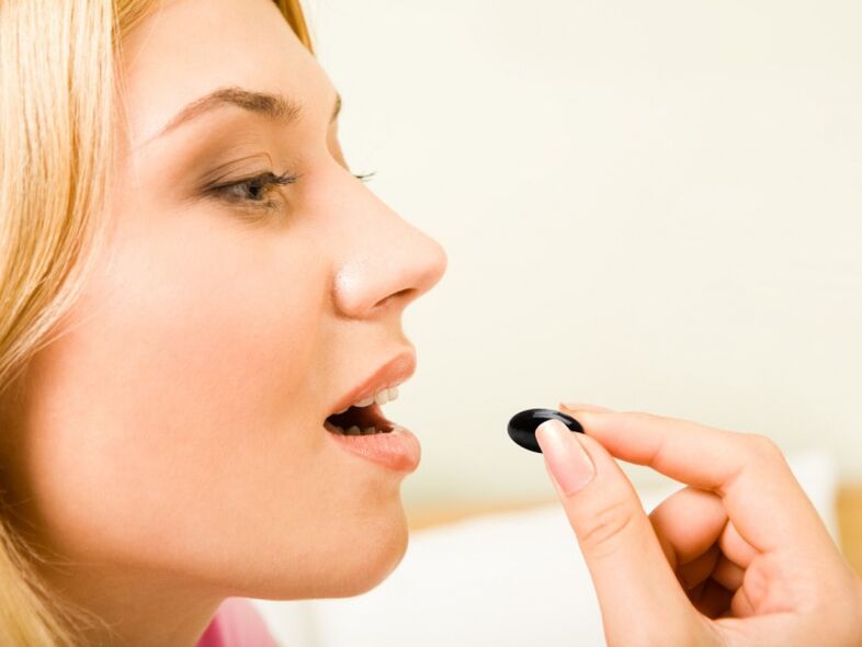 girl takes a pill to prevent worms